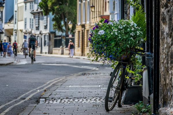 An image of Oxford's street, with an image of a bike against the wall